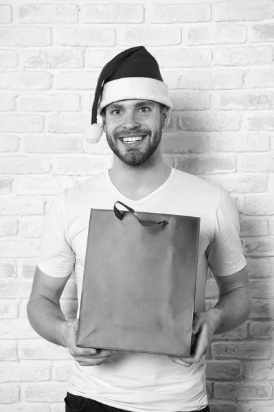 happy santa man. delivery christmas gift. man in santa hat hold christmas present. online christmas shopping. Happy new year, copy space. The morning before Xmas. Christmas fun. Winter holidays sales