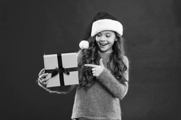 Happy winter holidays. New year new goals. Small girl. Present for Xmas. Childhood. Little girl child in santa red hat. New year party. Santa claus kid. Christmas shopping