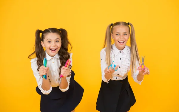 Arts for the future. Happy little schoolchildren holding drawing pens and scissors on yellow background. Educating future generation. Creativity is the skill of the future — Stock Photo, Image