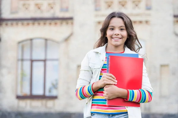 Biorąc dodatkowy kurs dla głębszego uczenia się. Edukacja szkolna. Wybór kursu. Nowoczesna edukacja. Dziecko uśmiechnięta dziewczyna szkoły uczeń trzymać skoroszytów podręczników do studiowania. Edukacja dla uzdolnionych dzieci — Zdjęcie stockowe