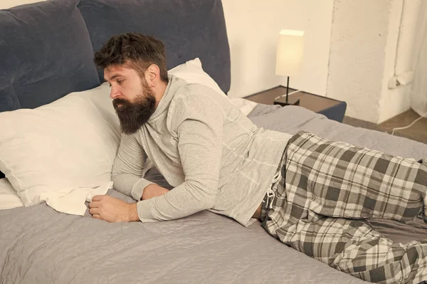 Difícil de despertar. El hombre barbudo hipster quiere dormir por la mañana. hombre somnoliento brutal en el dormitorio. macho maduro con barba en pijama en la cama. dormido y despierto. energía y cansancio. Despierta no hoy. — Foto de Stock