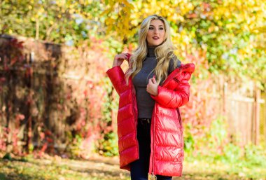 Sonbahar parkta makyaj standı ile kadın moda sarışın. Kız kırmızı parlak sıcak ceket giymek. Sonbahar moda konsepti. Bayan çekici fashionista ceket poz. Sonbahar sezonu konsepti için ceket