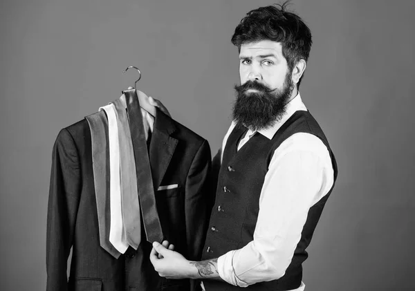 ¿Qué corbata debo usar? Hombre barbudo a juego con el color de la corbata del cuello para cubrir. Brutal hipster sosteniendo colorida colección de corbata y chaqueta de traje. Elegir una corbata perfecta — Foto de Stock