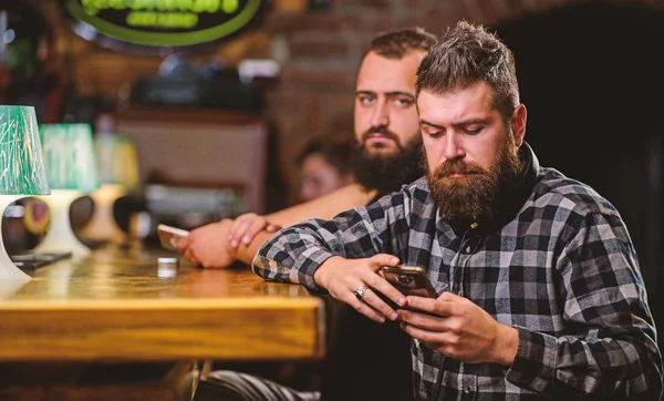 Peça bebidas no balcão do bar. Homens com smartphone relaxante no bar. Conceito de dependência móvel. O telemóvel está sempre comigo. Sexta-feira relaxamento no bar. Hipster barbudo homem passar lazer no balcão de bar — Fotografia de Stock