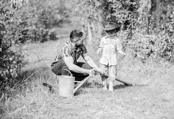 mutlu dünya günü. Aile ağacı hemşireliği. Baba ve oğlu çiftlikte kovboy şapkalı. sulama ve tencere kullanın. Bahçe ekipmanları. Eko çiftlik. küçük çocuk çocuk tarım baba yardım. Yalnızca en iyi sonuçları elde edin