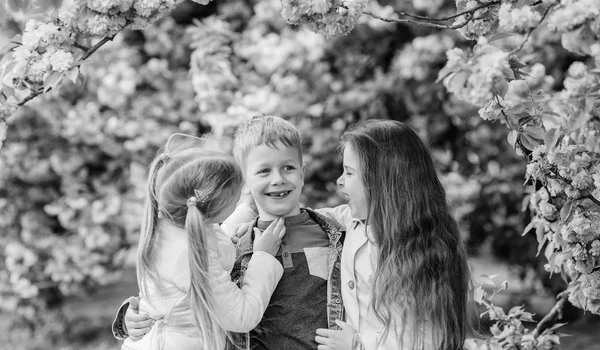 Happy spring vacation. Lost in blossom. Girls and boy friends posing near sakura. Kids on pink flowers of sakura tree background. Kids enjoying cherry blossom sakura. Children enjoy warm spring — Stock Photo, Image