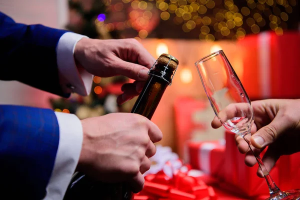 Celebre o Ano Novo com o champanhe. Mãos abrindo garrafa de champanhe e segure fundo decorações de Natal de vidro. Último minuto antes do ano novo. Contagem regressiva de ano novo. Beba champanhe ou espumante — Fotografia de Stock