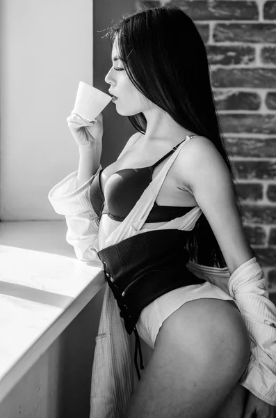 Menina curvas perfeitas corpo beber café perto do peitoril da janela. Mulher de roupa interior relaxante em casa. Hora perfeita do café. Mas primeiro café. Tranquilidade e paz. Um gole de cappuccino cremoso. Ritual matinal — Fotografia de Stock