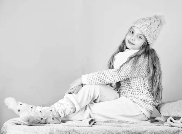 Chica pelo largo relajante fondo rosa. Moda de invierno para niños. Chico sonriente modelo de moda. Concepto de moda de invierno. Niña niña desgaste lindo de punto sombrero de moda y ropa cómoda y acogedora — Foto de Stock