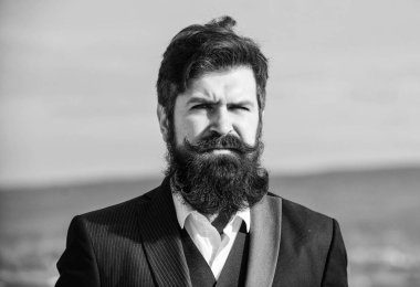 Adam sakallı hipster resmi takım mavi gökyüzü arka plan giymek. Vintage tarzı uzun sakal. Sakal ve bıyık bakımı. Sakal moda trendi. Şık bir görünüme yatırım yapın. Kalın sakalı hızlı uzatın