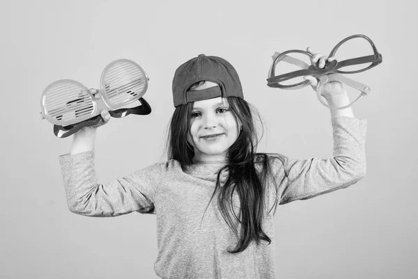 Att välja trendiga glasögon perfekt för hennes stil. Cool Party Girl välja fancy glasögon. Snyggt litet barn med mode glasögon. Söt liten Kid Holding Party glasögon — Stockfoto