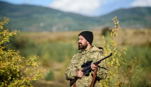 Hunter hold rifle. Bearded hunter spend leisure hunting. Focus and concentration of experienced hunter. Hunting and trapping seasons. Hunting masculine hobby. Man brutal gamekeeper nature background — Stock Photo, Image
