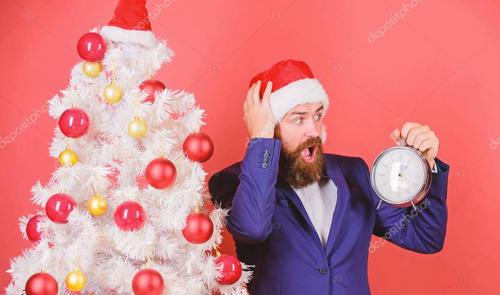 Last minute deals. Counting time till christmas. How much time left. Keep track of time. Time to celebrate. Man bearded wear suit and santa hat hold clock. Businessman join christmas celebration.