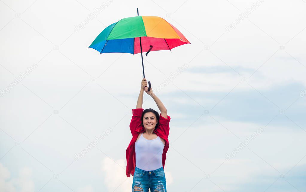 Parachute concept. Good weather. Welcoming fall. Pretty woman with colorful umbrella. Rainbow umbrella. Rainy weather. Good mood. Good vibes. Open minded person. Girl feeling good sky background