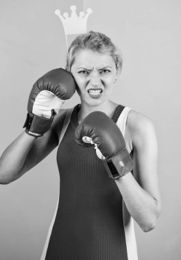 VIP salonu. Savaşçı kraliçe. Kadın boks eldiveni ve prensesin taç sembolü. Sporun kraliçesi. Boks sporunda en iyi ol. Kraliçe tacı takan dişi sarışın boks eldiveni giyiyor. Başarı için savaş