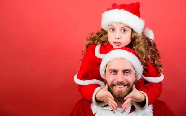 女の子小さなかわいい子供とひげを生やした父親はサンタの衣装を着ています。クリスマスパーティーサンタクロースの両親ガイドになる方法。父はサンタクロースです。サンタへの信仰は、子供の頃の最も魔法の部分を構成します — ストック写真