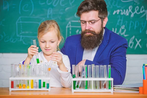 School chemistry experiment. Explaining chemistry to kid. How to interest children study. Fascinating chemistry lesson. Man bearded teacher and pupil with test tubes in classroom. Private lesson