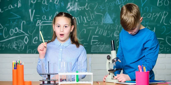 Παιδιά που σπουδάζουν μαζί στην τάξη. Σχολική εκπαίδευση. Χημική ανάλυση. Τα παιδιά σπουδάζουν χημεία. Μάθημα χημείας στο σχολείο. Σχολικό εργαστήριο. Κορίτσι και αγόρι επικοινωνούν ενώ διεξάγουν σχολικό πείραμα — Φωτογραφία Αρχείου
