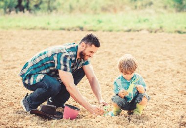 dünya günü. küçük çocuk çocuk tarım baba yardım. mutlu dünya günü. Aile ağacı. zengin doğal toprak. Eko çiftlik. Eğleniyorlar. toprak ve gübre. baba ve oğul toprağa çiçek dikimi