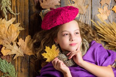 Moda şapka trendi sonbahar sezonu. Çocuk kız parlak yumuşak örme şapka sonbahar tadını çıkarın. Örme şapka kız sevimli çocuk ahşap arka plan düşmüş akçaağaç üst görünümü bırakır yatıyordu. Sonbahar moda şapka aksesuarı