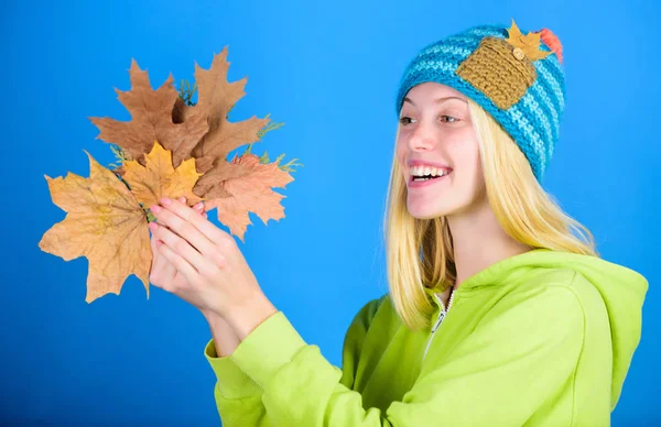 Skincare routine for autumn. Enjoy autumn season. Autumn skincare tips. Bright moment. Skincare and beauty tips. Active leisure and rest autumn season. Woman wear knitted hat hold fallen leaves