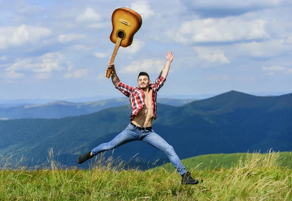 Guy hiker enjoy pure nature. Man with guitar walking on top of mountain. Vacation destinations. Fresh mountain air. Exploring nature. Beauty of nature. Looking for inspiration. Walking alone