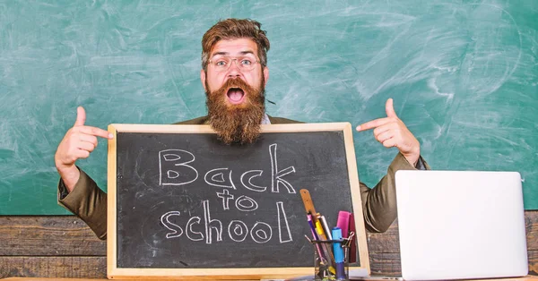Come to us. Teacher welcomes new pupils enter educational institution. Teacher or school principal welcomes with blackboard inscription back to school. Private school advertising to boost enrollments