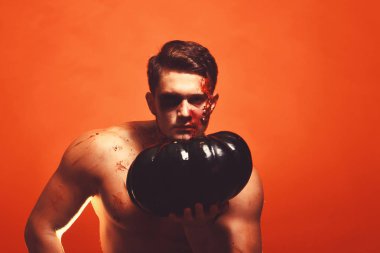 Gövdeli maço balkabağı tutar. Ciddi yüzlü adam