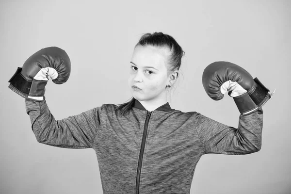 Boxerin. Sportliche Erziehung. Boxen sorgt für strenge Disziplin. Mädchen niedlichen Boxer auf blauem Hintergrund. Mit großer Macht kommt große Verantwortung. Entgegen dem Stereotyp. Boxerkind in Boxhandschuhen — Stockfoto