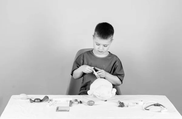 Geneeskunde concept. Medische procedures voor teddybeer. Medisch onderzoek. Medische educatie. Jongen schattig kind toekomstige arts carrière. Gezondheidszorg. Kid weinig dokter drukke Sit tabel met medische hulpmiddelen — Stockfoto