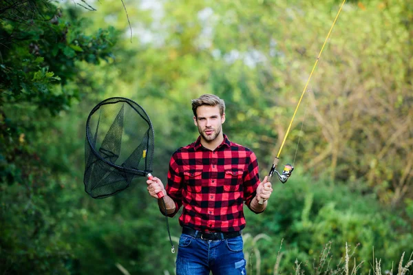夏季周末概念。钓鱼日。帅哥在格子衬衫与钓鱼设备自然背景。钓鱼在我的爱好。带杆旋转网的嬉皮士渔夫。希望好钓鱼 — 图库照片