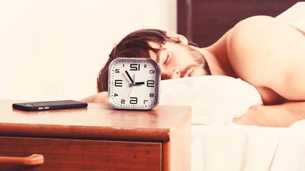 El tipo está acostado en la cama. Un joven despertando en la cama y estirando los brazos. Hombres felices en la cama. — Foto de Stock