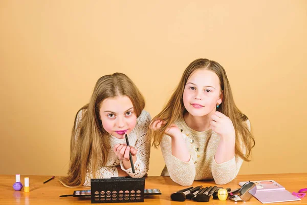 Artistas ajudando a olhar bom. Artistas de beleza adoráveis fazendo maquiagem. Pequenos maquiadores dando tutorial de beleza. Pequenos artistas de maquiagem bonitos aplicando batom nos lábios — Fotografia de Stock