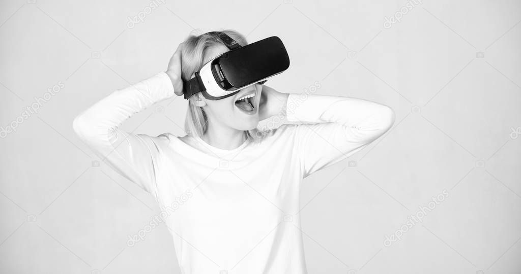 Amazed young woman touching the air during the VR experience. A person in virtual glasses flies in room space. Woman excited using 3d goggles. VR digital.