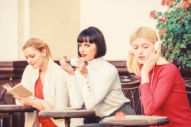 Dinlenmek ve şarj etmek için bir yol. Kadın boş. Grup güzel kadın Teras okuma ve dinleme ile kendilerini eğlendirmek. Hobi ve eğlence. Farklı ilgi alanları. Hafta sonu dinlenmek ve eğlence. Kahve kafesi