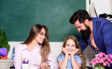 Kıza ders veriyor. Anne ve baba öğretmenler öğrenme ile çocuk yardımcı olur. Öğrenmek için uygun koşullar. İyi bir öğrenme ortamı. Öğrenciler, kendilerini desteklenmiş ve saygı duyulan hissetmeli. Akıllı aile