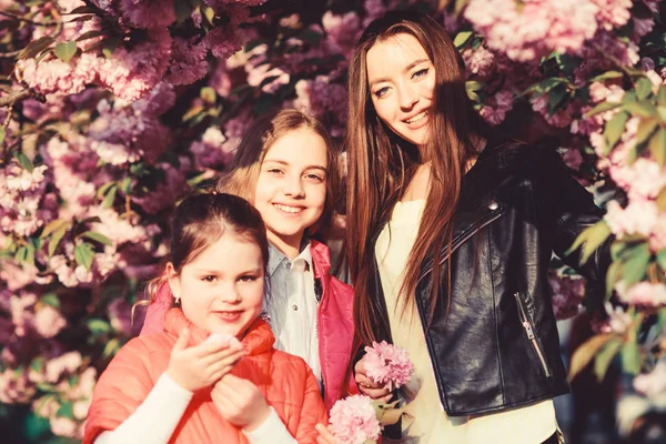 blossom smell, allergy. Sisterhood. Natural beauty. Mothers day. happy sisters in cherry flower. Sakura bloom. family summer. small children and mother in spring flower. Enjoying spring day