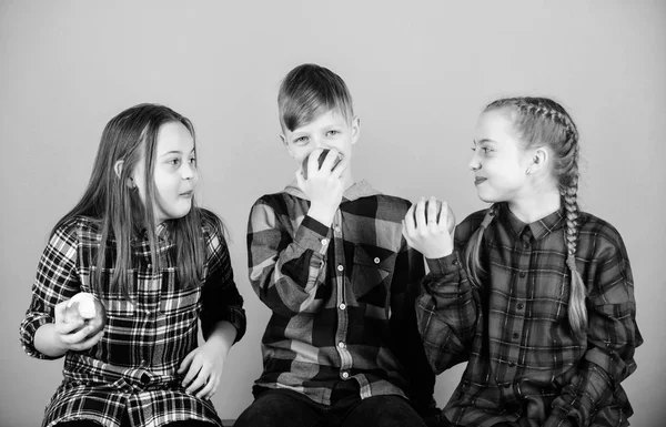 Gruppo allegro adolescenti divertirsi e mangiare mele. Dieta sana e nutrizione vitaminica. Gli amici maschi e femmine mangiano snack di mele mentre si rilassano. Concetto di snack scolastico. Adolescenti con spuntino sano — Foto Stock