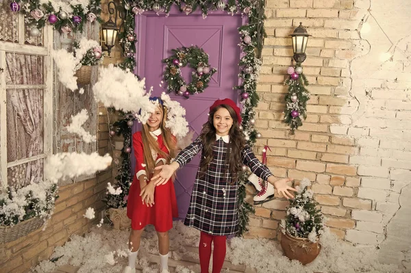 Diversión de diciembre. Juegos infantiles en vacaciones de invierno. Chicas pequeñas con decoración navideña. Los niños felices celebran la Navidad y el año nuevo. Los niños pequeños lanzan nieve artificial. Diversión de invierno — Foto de Stock