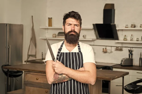 Cocinar es mi pasión. hombre brutal en delantal de cocinero con cuchillo afilado. macho maduro con barba cocida. negocios culinarios. sabrosa cocina. chef serio y seguro en la cafetería. barbudo hombre hipster en cocina —  Fotos de Stock