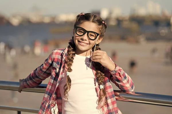 Giving every child a happy childhood. Adorable little girl with happy smile and funny look through prop glasses. Happy small child with big smile on summer day. Happy international childrens day