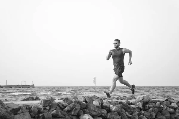 El dolor no es nada comparado con lo que se siente dejar de fumar. Hombre corriendo en la playa. Entrenamiento de corredores al aire libre. Ajuste el ejercicio físico masculino del deporte en verano. Ejecutar deporte y hobby. Hombre entrenador de fitness — Foto de Stock