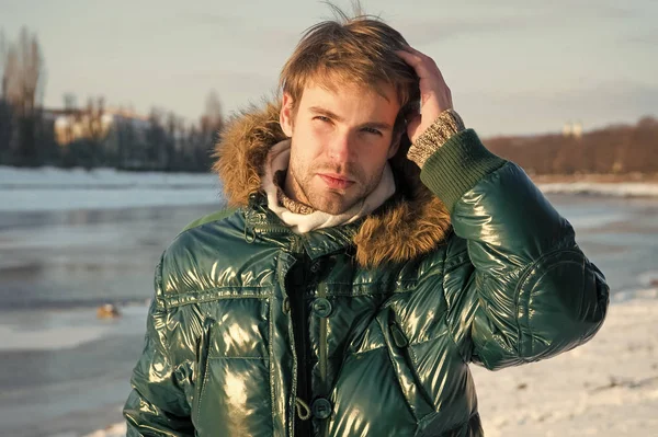 Invierno ropa de hombre elegante. Traje de invierno. Hombre barbudo soporte cálido chaqueta nieve naturaleza fondo. Hipster traje de moda de invierno. El tipo usa chaqueta con capucha en el helado día de invierno. Ropa resistente al viento —  Fotos de Stock