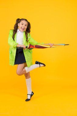 Bir sonbahar gününde im mutlu. Yağmur giyen küçük çocuk sonbahar günü okula gidiyor. Küçük çocuk parlak şemsiye ile gülümseyen yağmurlu havalarda onu koruyan. Sonbaharda sevimli ve pratik giyinme