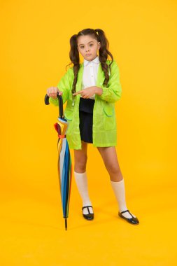 Sonbahar yağmuru. Okula gidiyorum. Yağmur geçirmez kıyafetler. Yağmur bitti. Yağmur yağıyor. Yağmurlu günleri bekliyorum. Şemsiye ile Schoolgirl şık küçük çocuk su geçirmez yağmurluk giymek. Suya dayanıklı giysiler