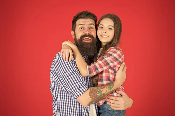 Édes ölelés. Az ember szakállas, apa és aranyos kis lány lánya vörös háttérben. Apák napja megünneplésére. Családi értékek koncepció. Családi kötvények. Baráti kapcsolatokat. Csípő apa és lánya — Stock Fotó