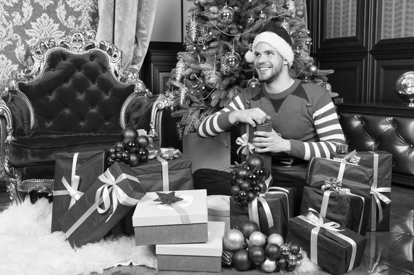 Tu n'auras ça qu'à Noël. Livraison cadeaux de Noël. Il fête Noël à la maison. Un homme au chapeau de Père Noël tient des cadeaux de Noël. Un homme heureux avec des coffrets cadeaux de Noël. La saison pour être joyeux — Photo