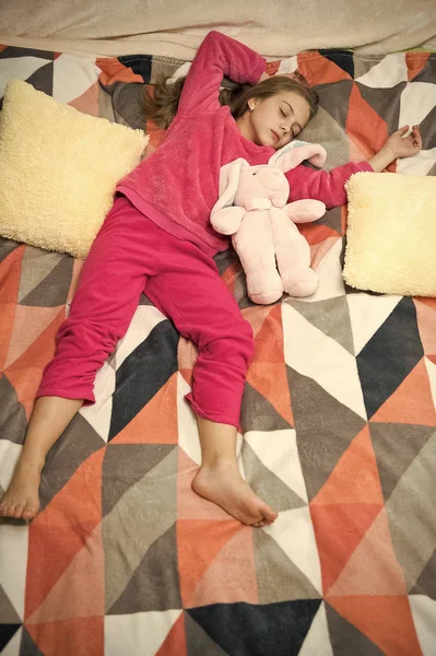 Small girl child ready to sleep. Time to relax. Childhood happiness. Pajama party. Good night. Little happy girl in bedroom. Good morning. International childrens day. What an interesting toy — Stock Photo, Image