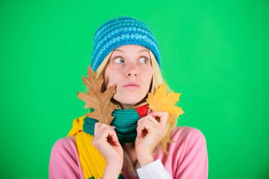 Sonbahar için cilt bakımı rutininizi nasıl güncellersiniz? Sonbahar cilt uçları. Sağlıklı cilt. Cilt bakımı ve güzellik tavsiyeleri. Şirin bir kadın örülmüş şapka giyer. Düşmüş yaprakları tutar. Deri yenileme ve onarım zamanı.