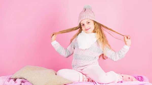 Acessório de moda de inverno para criança. Conceito de acessório de inverno. Menina jogar cabelo longo fundo rosa. Kid sorrindo desgaste de malha acessório. Menina criança vestir bonito tricotado chapéu elegante e cachecol acessório — Fotografia de Stock